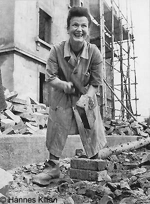 Lachende "Trümmerfrau"  beim Aklopfen von Backsteinen, Copyright Hannes Kilian, Foto 1948